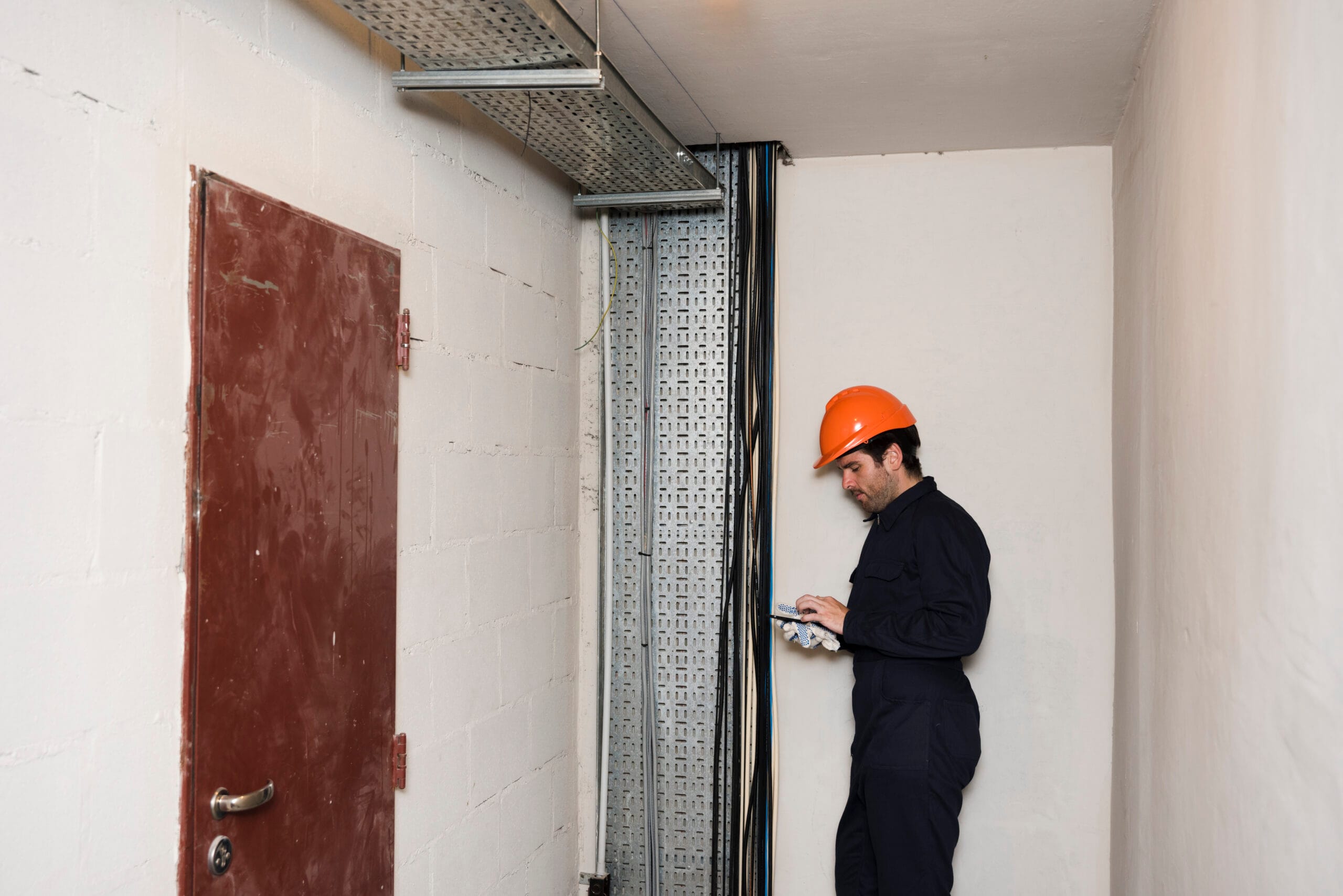 side-view-male-electrician-using-mobile-phone-work